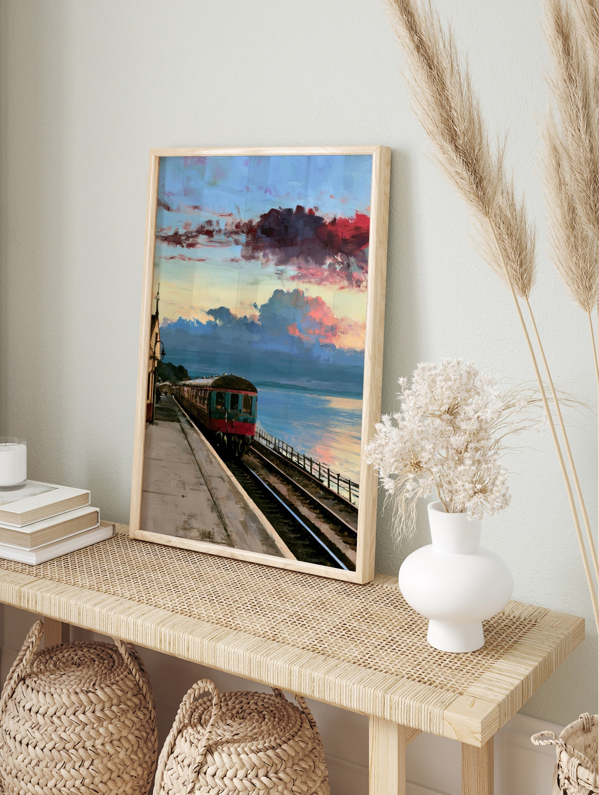 Vintage train carriage at a coastal railway station under a dramatic red and blue sunset sky, in an alternate framed mockup