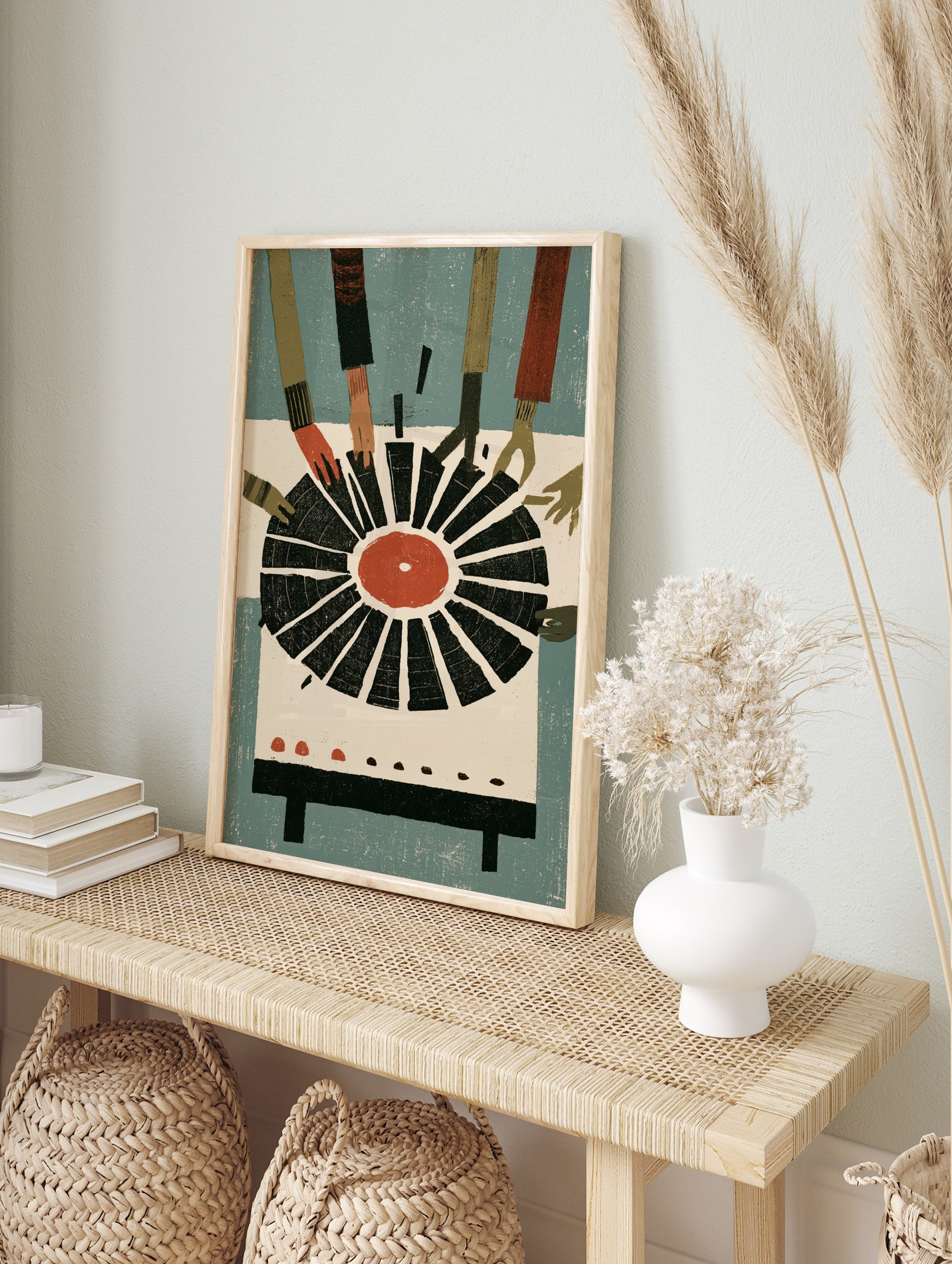 Illustrative print of hands reaching for a vinyl record with a red centre against a blue, in an alternate framed mockup