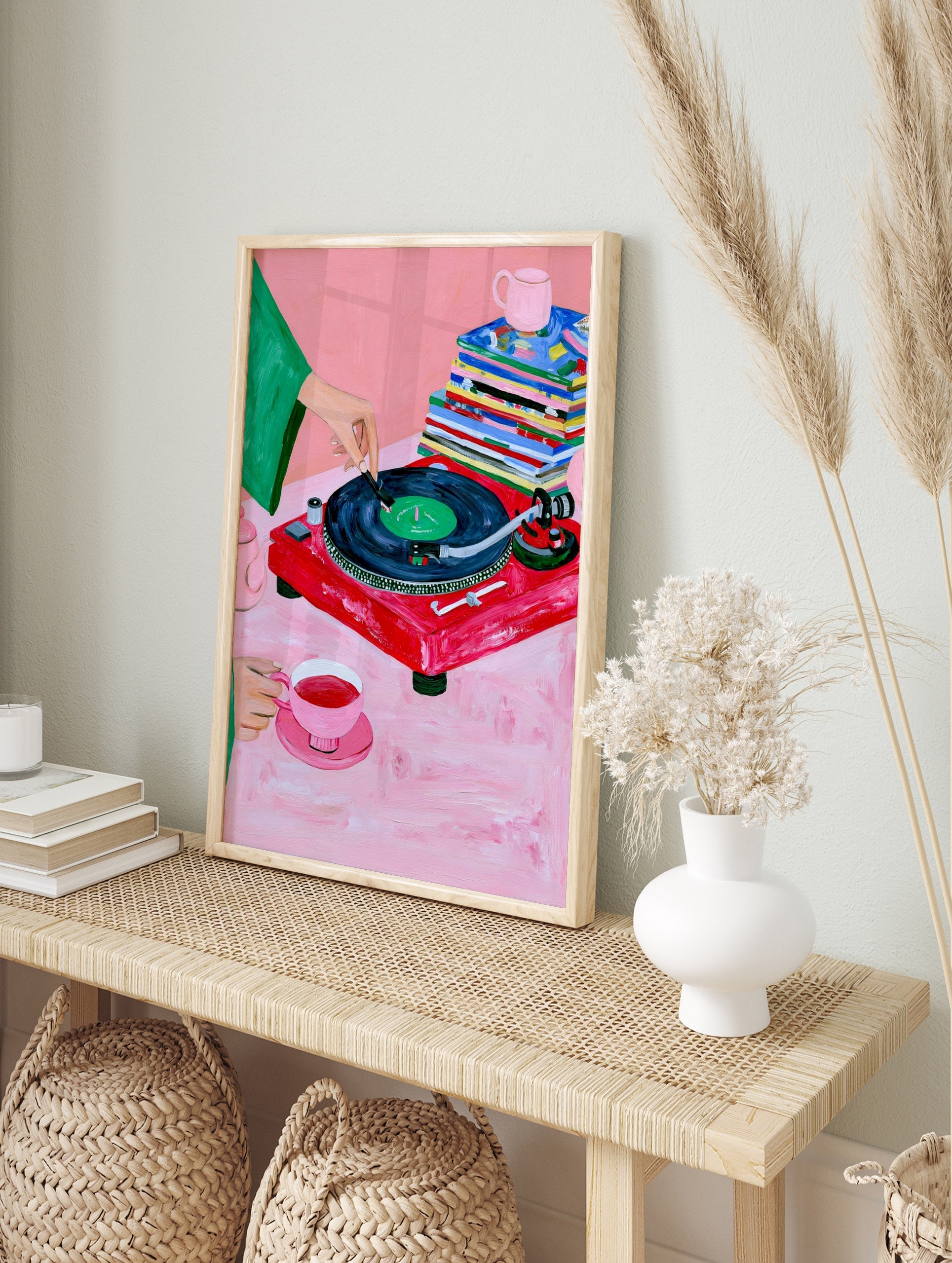 Illustrative art print of a red vinyl record player, tea set, and magazines on a pink, in an alternate framed mockup