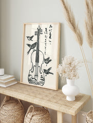 Black and white illustrative violin with four birds and Japanese calligraphy on white, in an alternate framed mockup