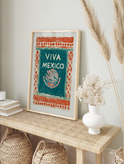 Viva Mexico art print with an eagle, snake, and cactus emblem on a teal-green panel with an, in an alternate framed mockup