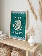 Viva Mexico Wall Art with white Mexican eagle emblem on dark green, blue patterned borders, in an alternate framed mockup