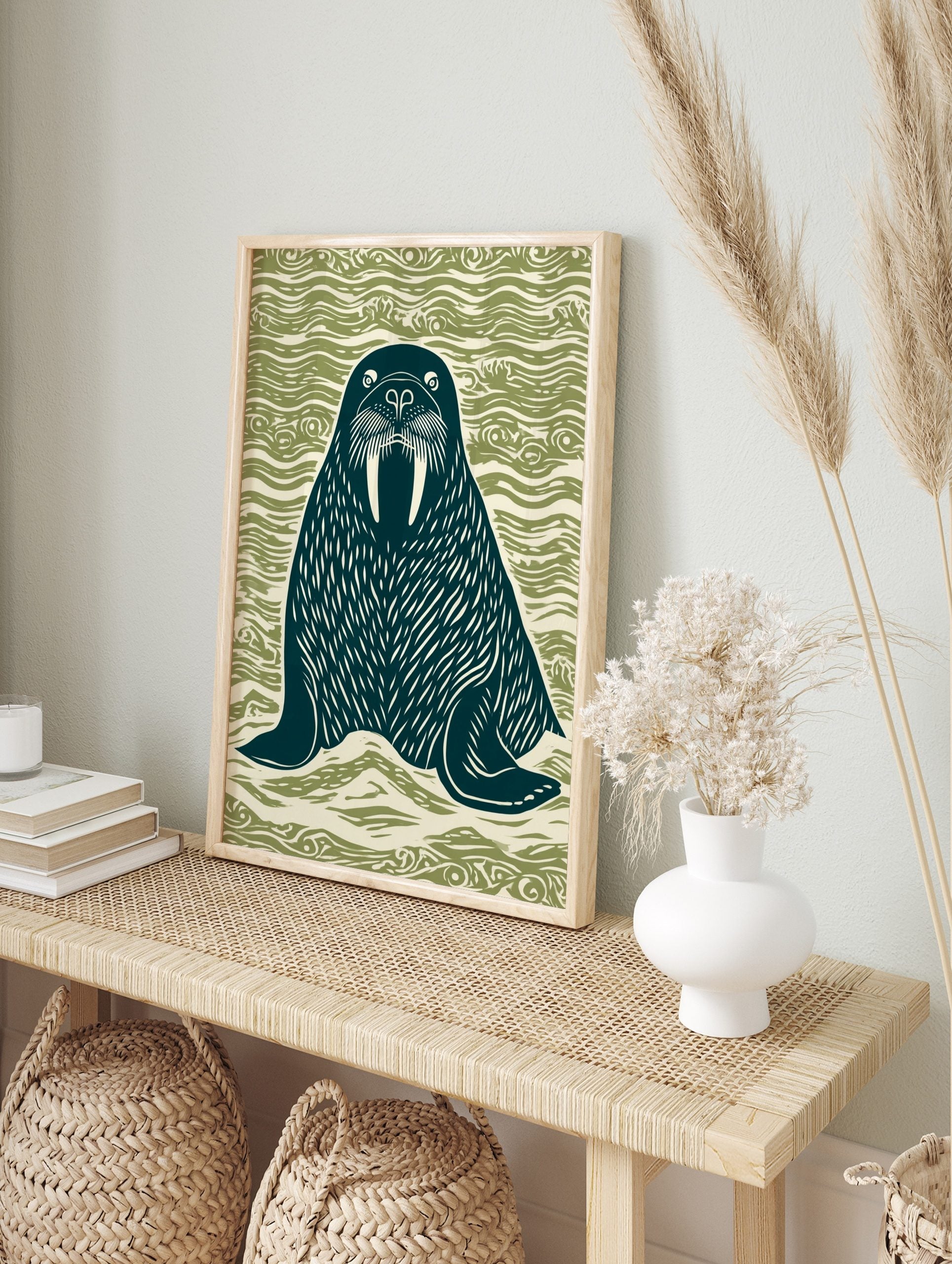 Linocut style walrus illustration with large tusks, dark teal on wavy green background, in an alternate framed mockup
