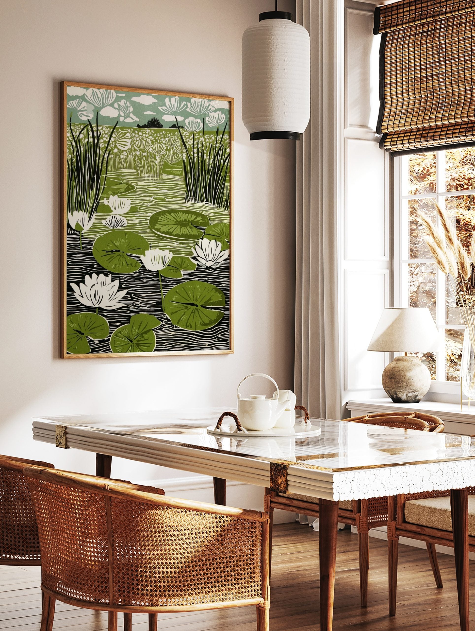 Linocut print of a pond with white water lilies, green lily pads, and tall reeds against a floral, in a styled room mockup