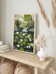 Illustrative green and white water lily pond print with stepping stone path and garden foliage, in an alternate framed mockup