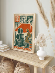Woodcut style art print of a market with stacked green watermelons, a vendor, and red kanji, in an alternate framed mockup