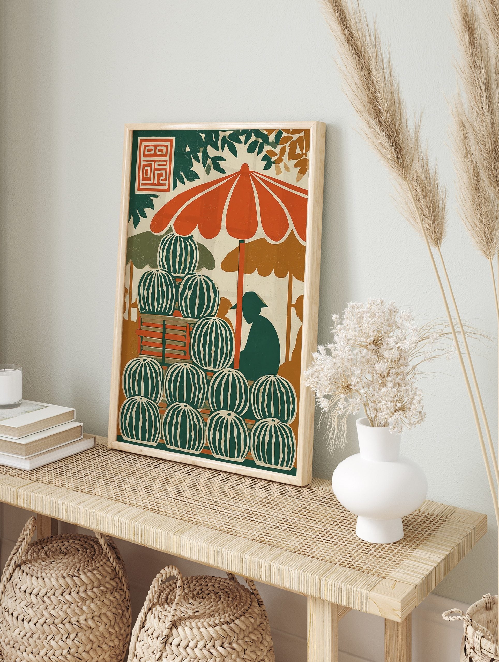 Illustrative print of a watermelon stand with stacked fruit, orange umbrella, and vendor, in an alternate framed mockup