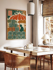 Illustrative print of a watermelon stand with stacked fruit, orange umbrella, and vendor silhouette, in a styled room mockup