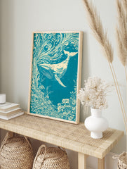 Illustrative whale swimming through swirling floral currents in teal and cream, in an alternate framed mockup