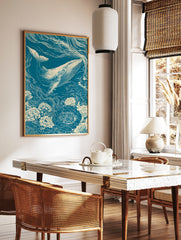 Linocut-style illustration of a whale swimming through a field of flowers in teal and cream tones, in a styled room mockup