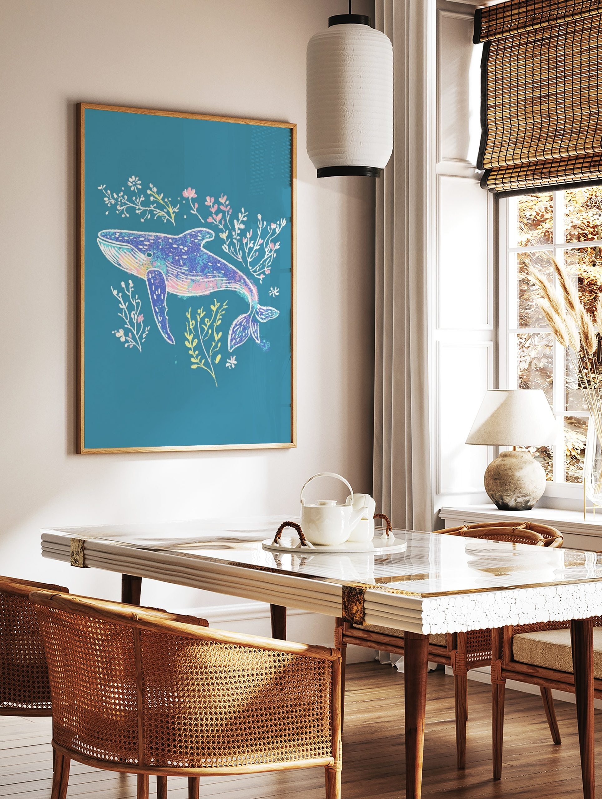 Illustrative blue whale art print with pink, yellow, and white seaweed on a teal background, in a styled room mockup