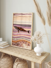 Indigenous style dot art print of a whale swimming horizontally amidst abstract purple and, in an alternate framed mockup