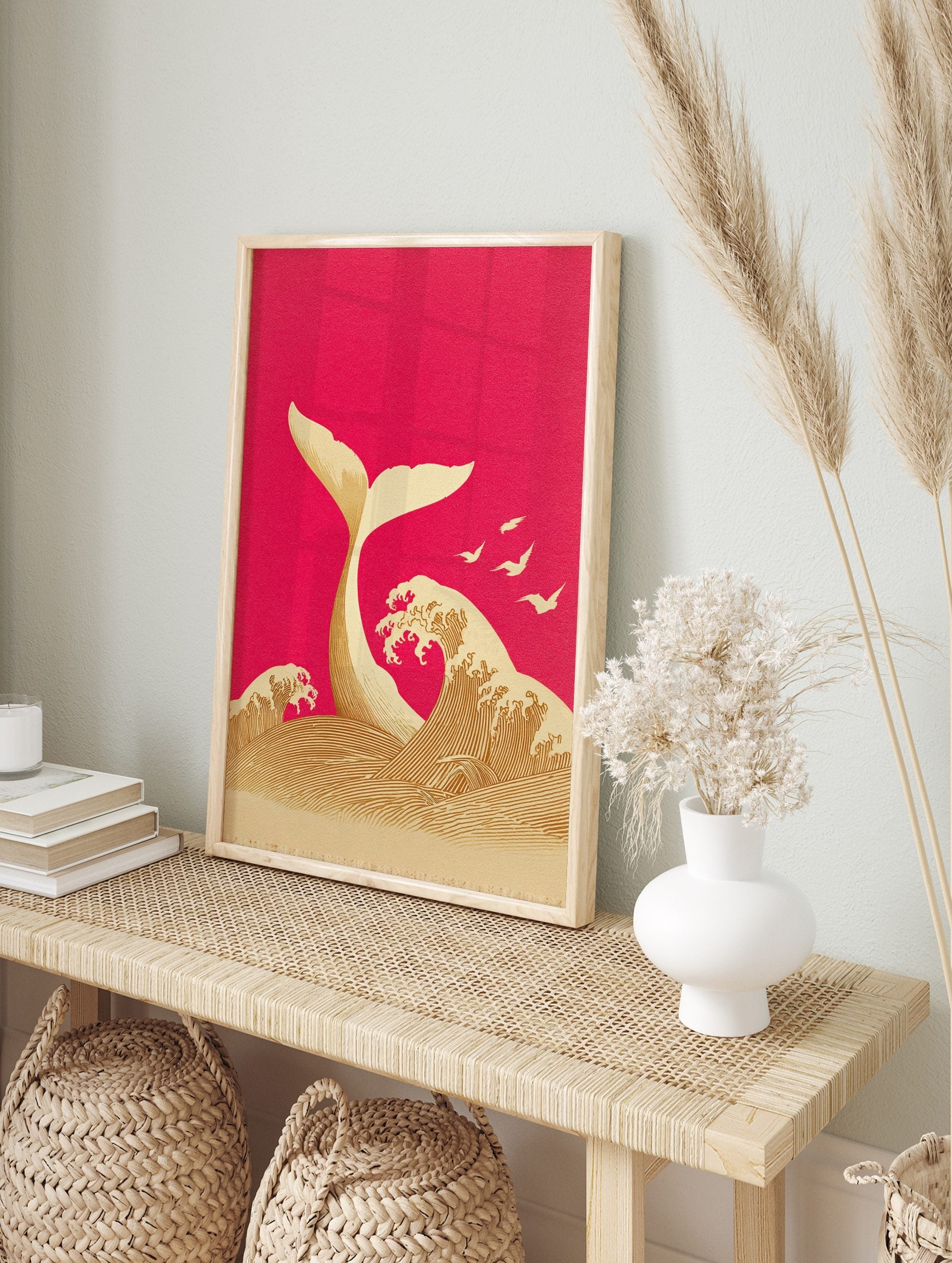 Illustrative whale tail emerging from ocean waves with birds on magenta background, in an alternate framed mockup