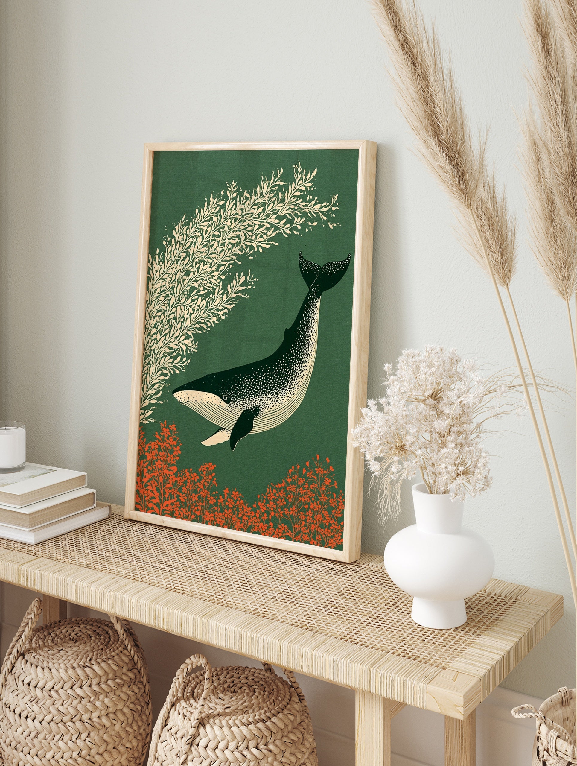 Stylized illustration of a speckled whale swimming past cream foliage on a dark green, in an alternate framed mockup