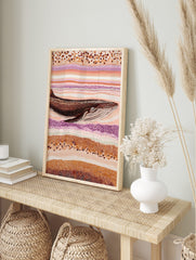 Whale art print in Aboriginal dot painting style with brown, orange, cream, and purple wavy, in an alternate framed mockup