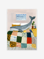 Illustrative whale wall art print showing a blue whale on a colorful patchwork quilt in a bedroom with a yellow nightstand.