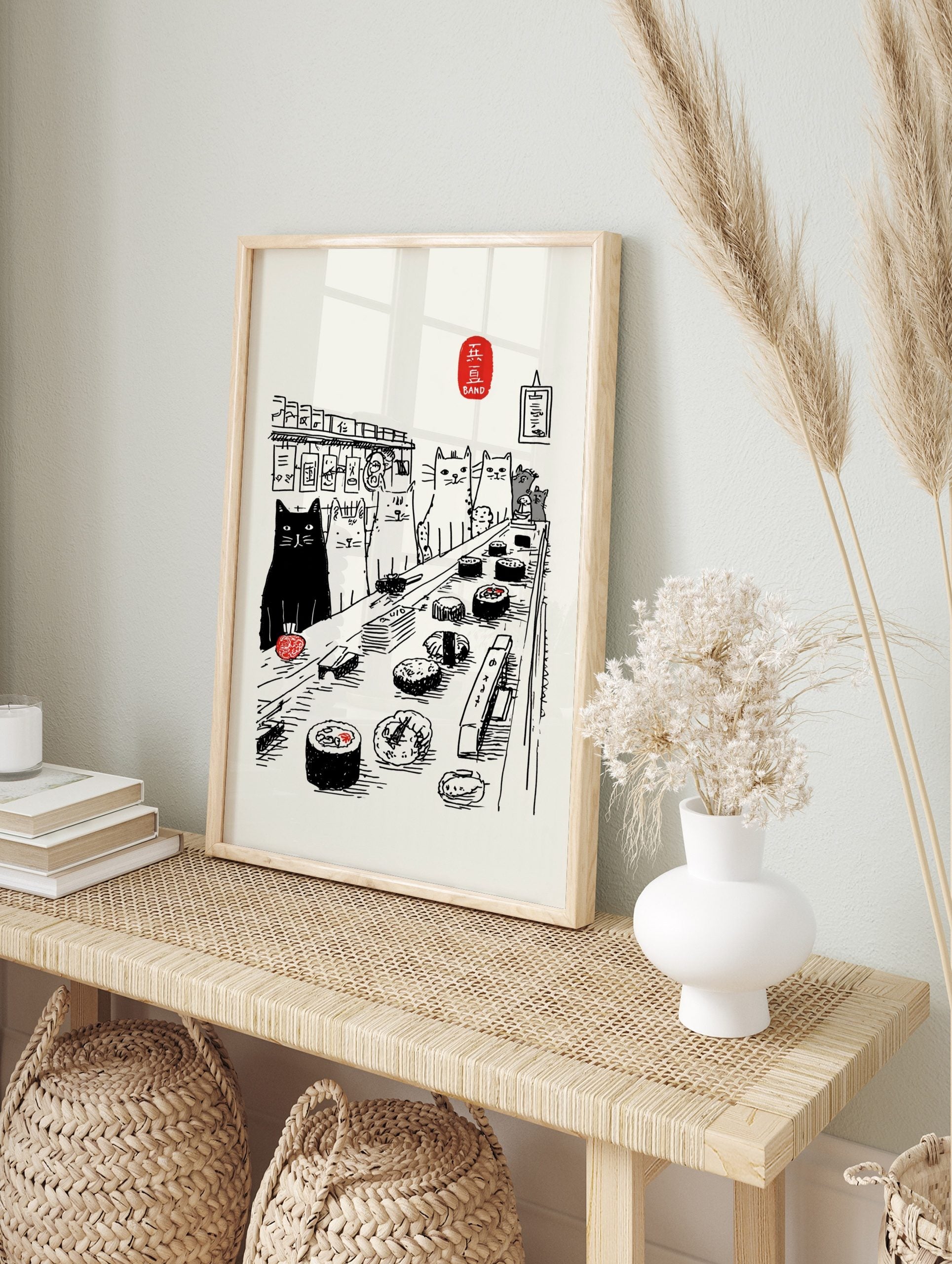 Illustrative print of cats observing sushi on a conveyor belt, with a black cat and Japanese, in an alternate framed mockup