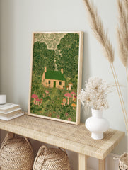 Illustrative print of a whimsical cottage with green roof, surrounded by lush green trees and, in an alternate framed mockup