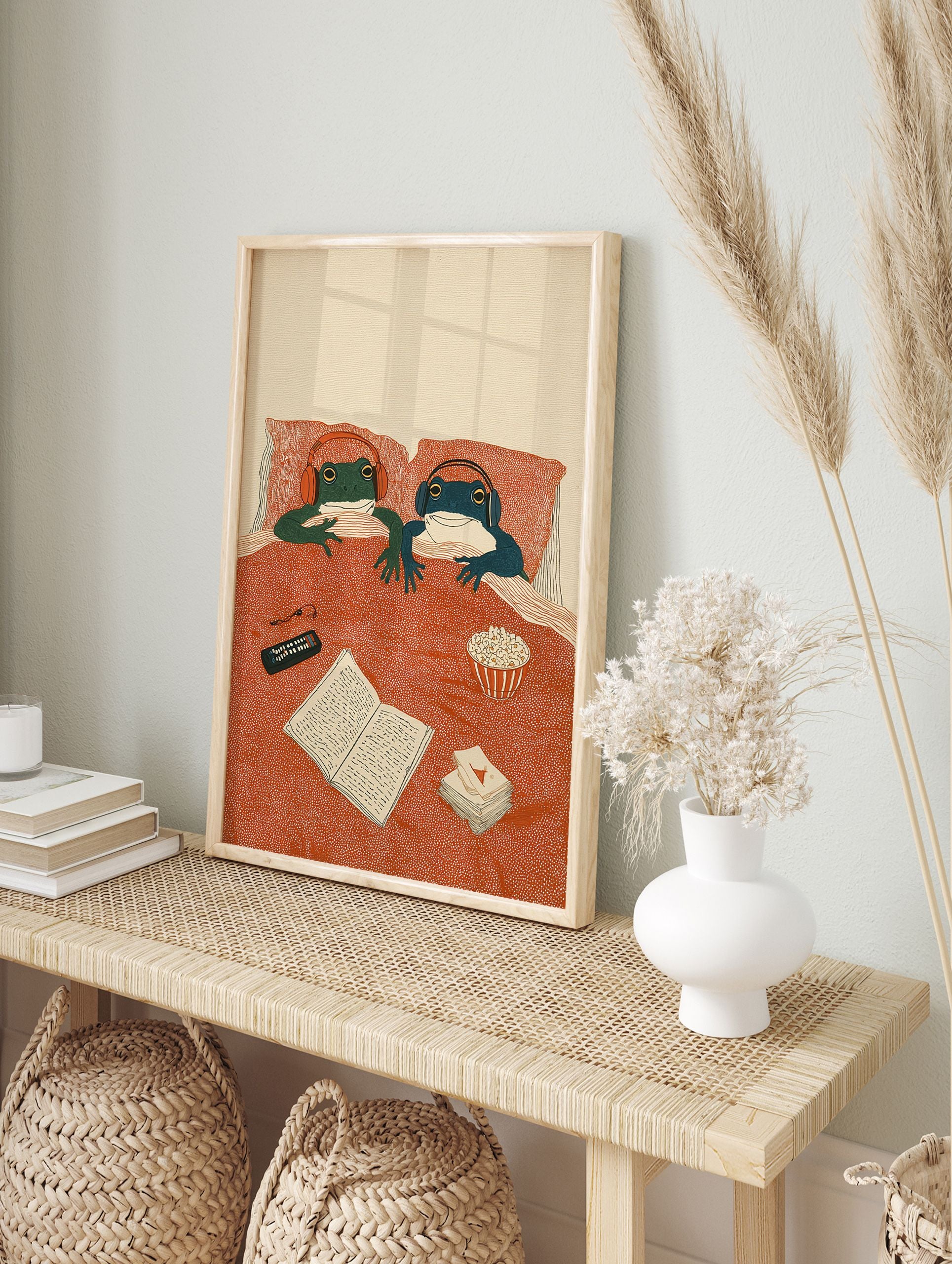 Illustrated frog art print of two frogs in bed with headphones, remote, book, and popcorn, enjoying a cozy night in. - Image 3