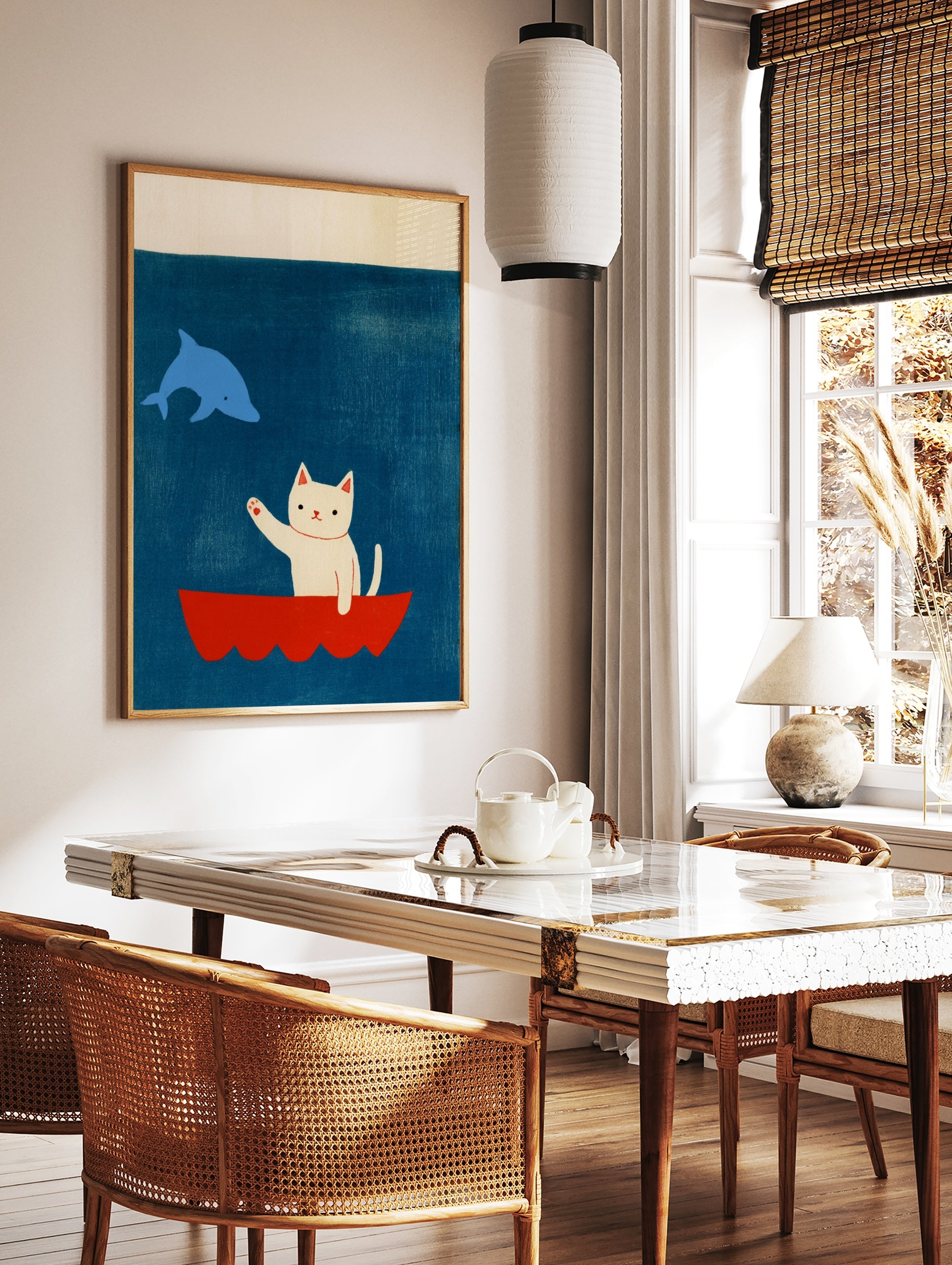 Illustrative art print featuring a white cat waving from a red boat at a blue dolphin against a, in a styled room mockup