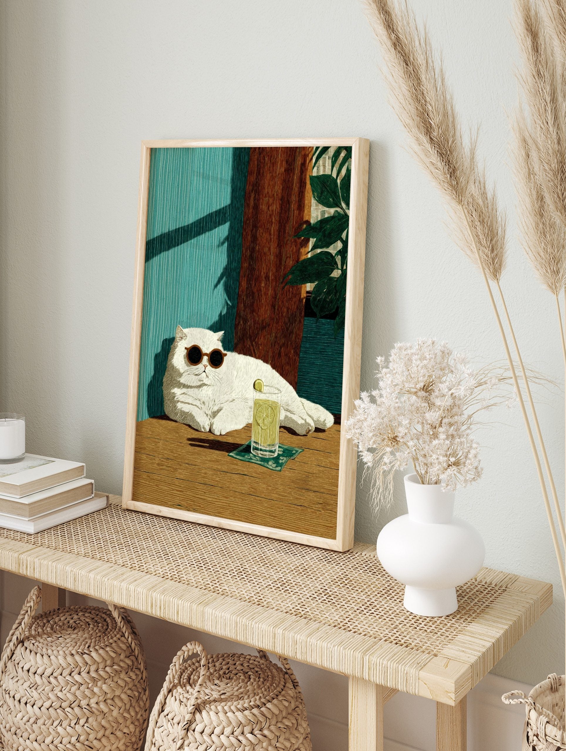 Illustrative print of a white cat in sunglasses with a lime drink, against a teal wall and, in an alternate framed mockup