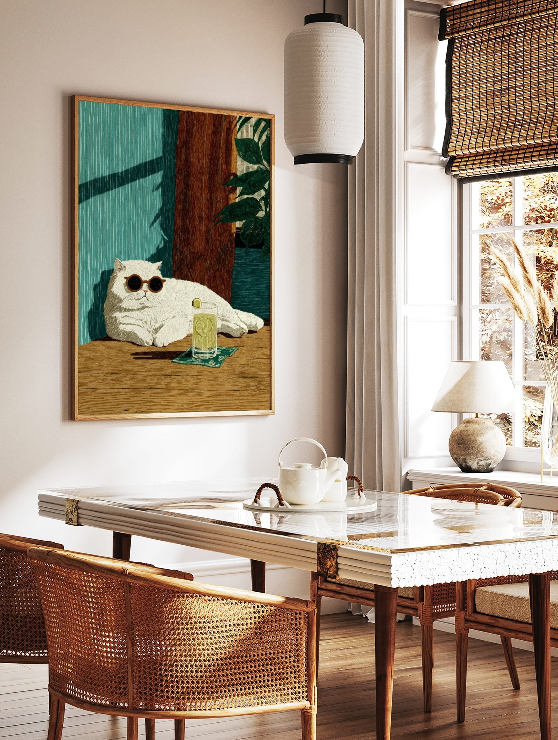 Illustrative print of a white cat in sunglasses with a lime drink, against a teal wall and wooden, in a styled room mockup