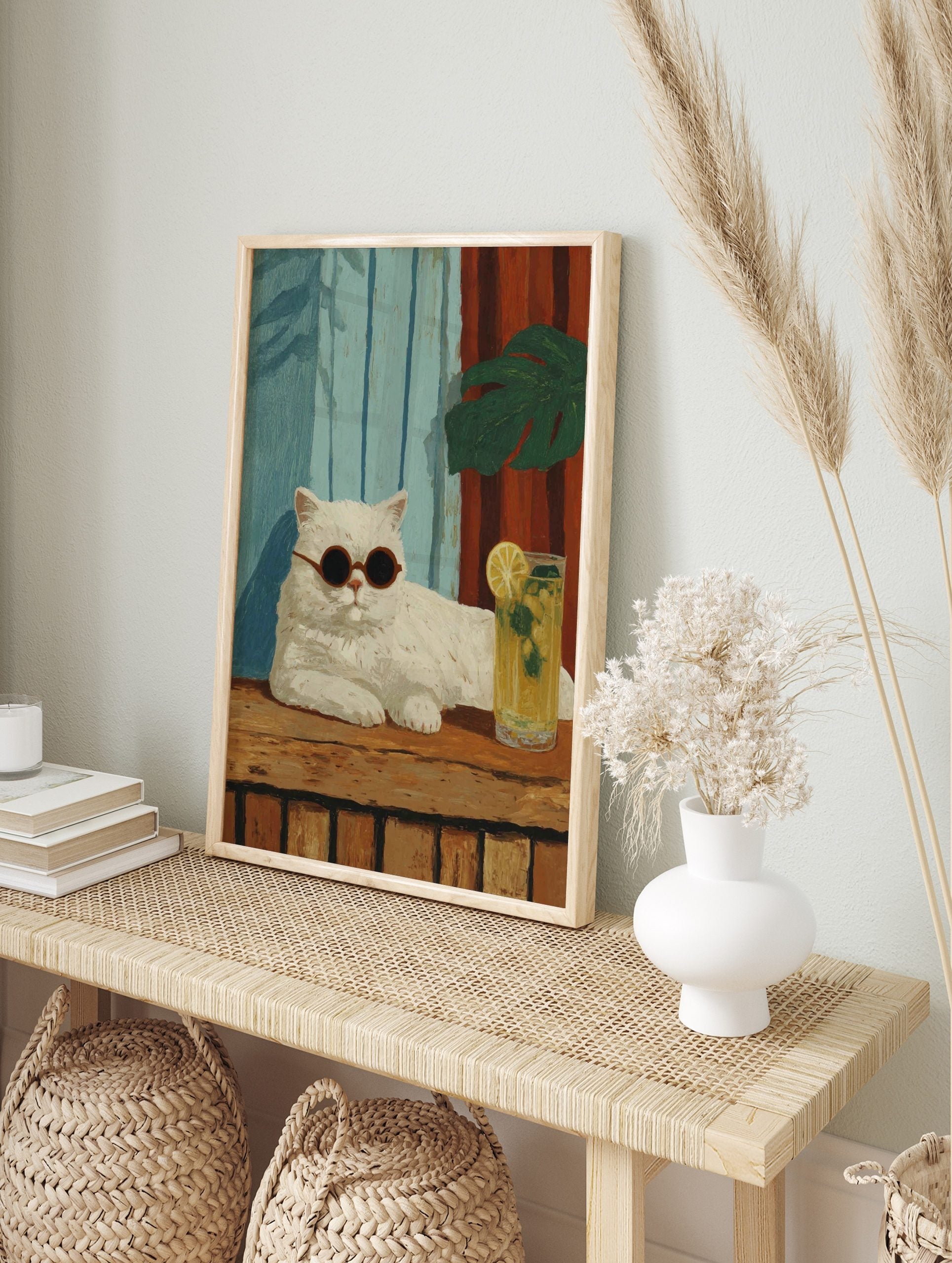 Illustrative white cat with round sunglasses, lemonade, blue and red striped background, in an alternate framed mockup