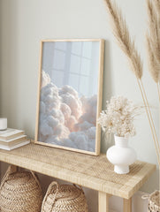 Voluminous white clouds with soft, warm glow against a light blue sky, filling the bottom of, in an alternate framed mockup