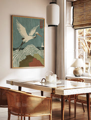 Japanese woodblock print of a white crane flying over swirling stormy waves and rain, with a, in a styled room mockup
