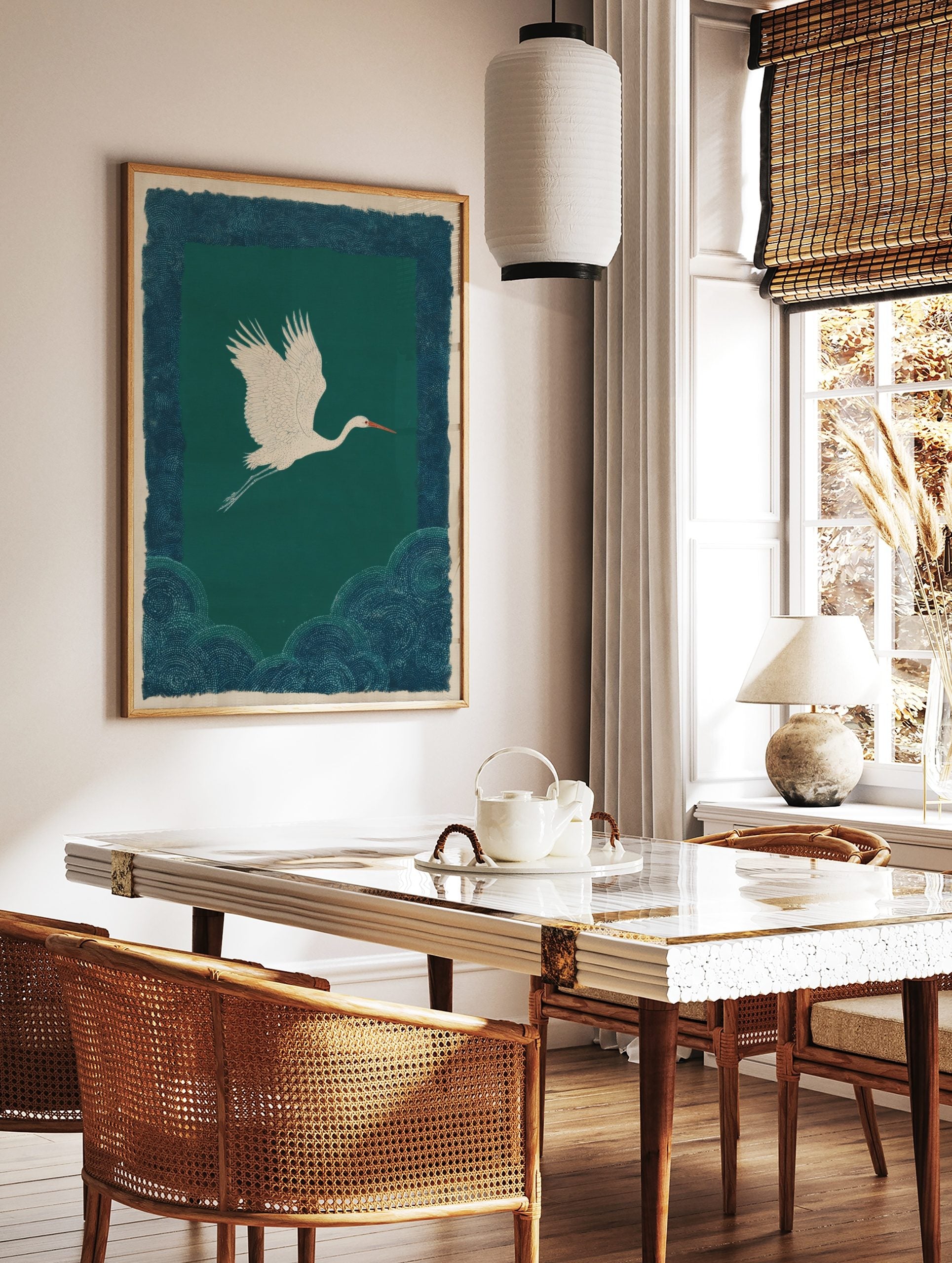 White crane flying against teal background with patterned dark blue borders in illustrative style, in a styled room mockup