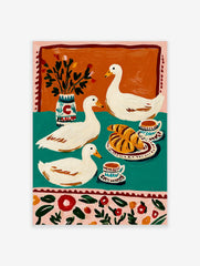 Illustrative print of three white ducks with croissants, coffee, and a vase on a teal and orange background