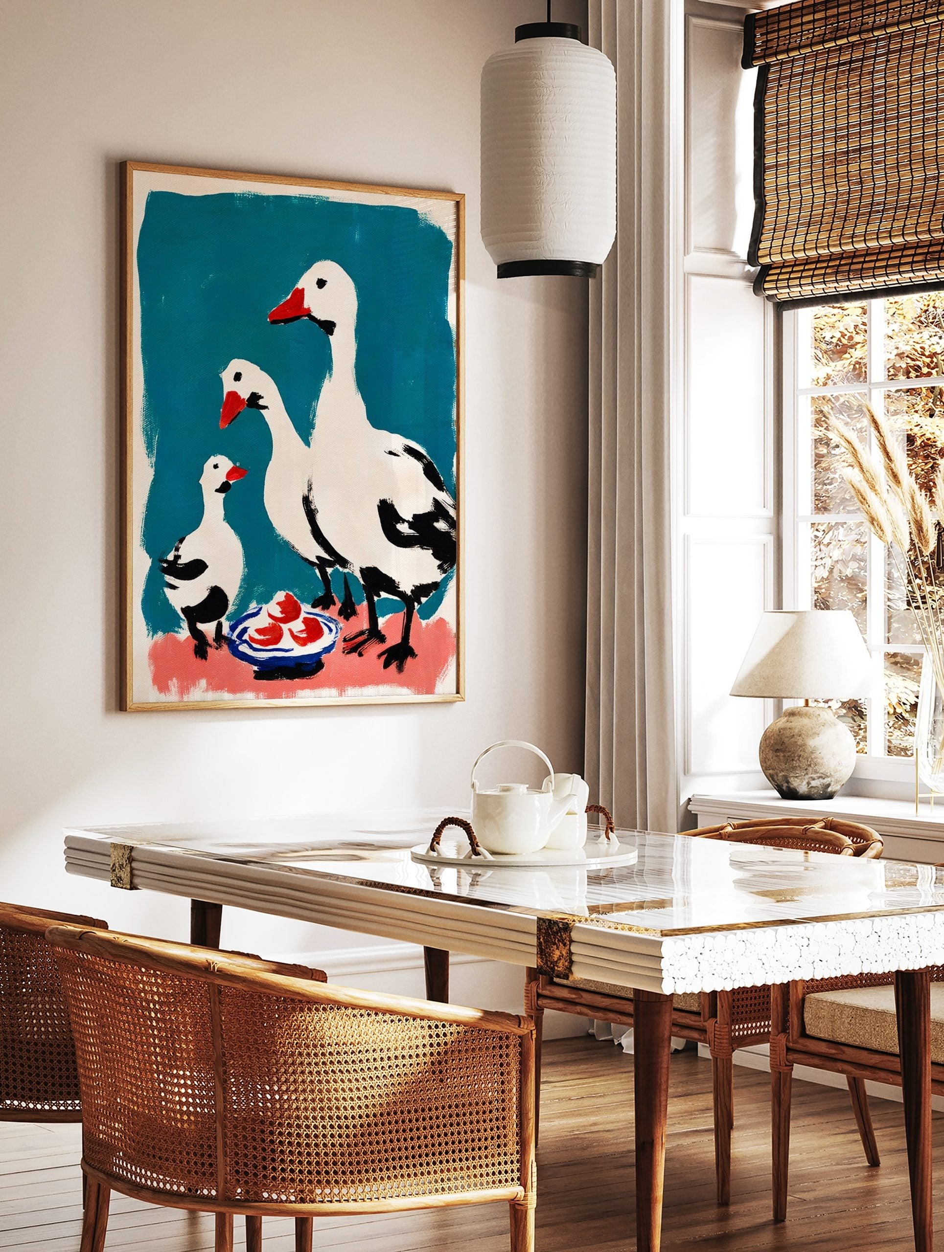 White geese family wall art with red beaks and black details on teal and pink background with a, in a styled room mockup