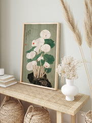 Japanese woodcut style illustration of white mushrooms with red accents and green leaves, in an alternate framed mockup