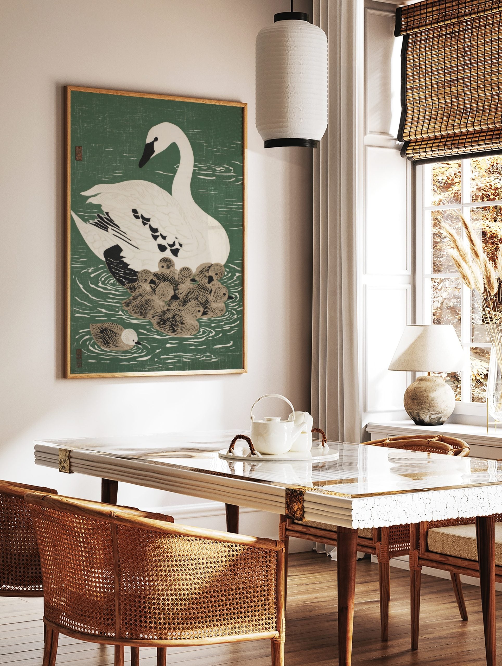 White swan with black beak and eye swimming with a cluster of brown cygnets on green water, in a styled room mockup