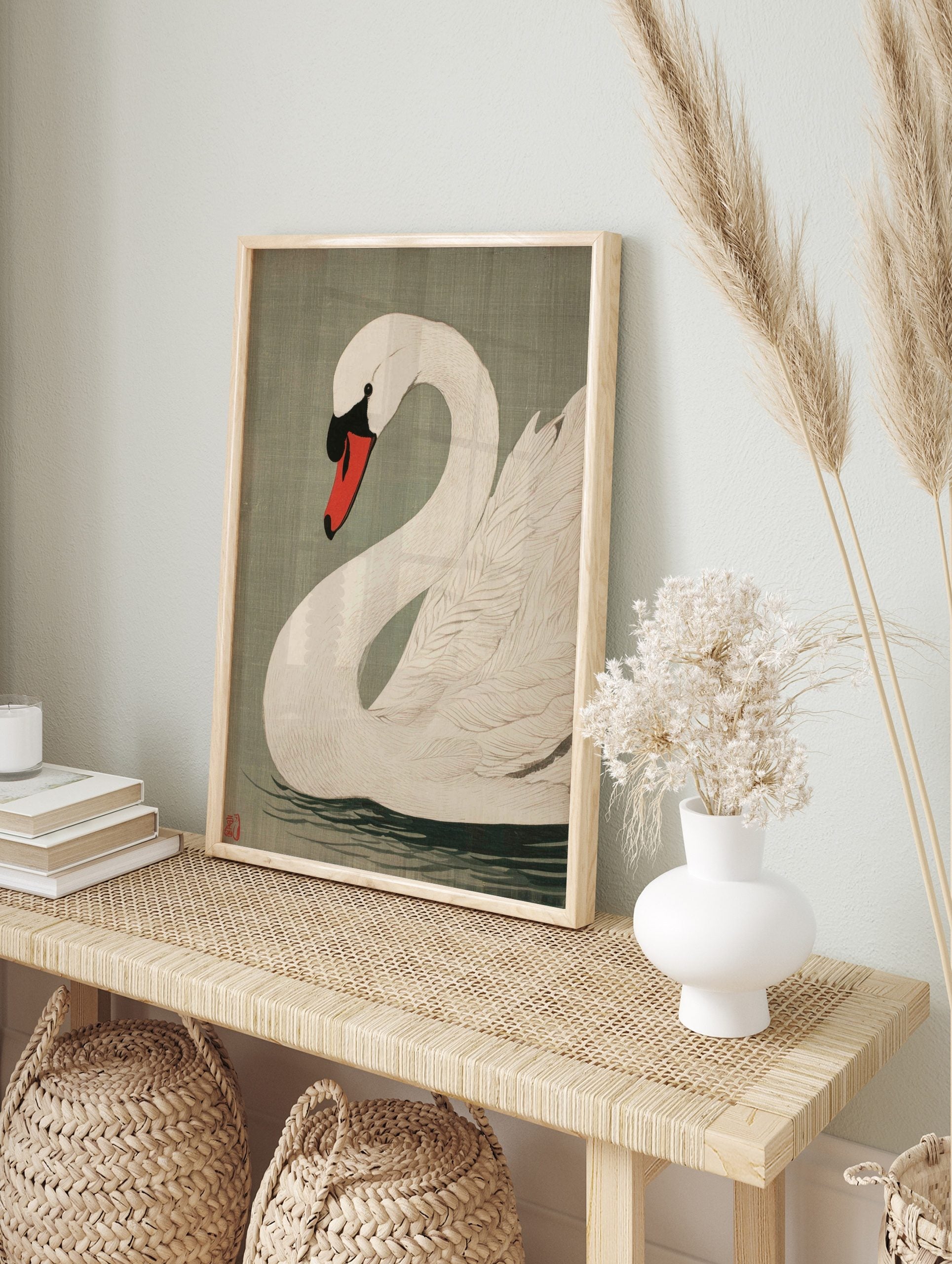 White swan woodblock style art print with red and black beak, on sage green background, in an alternate framed mockup