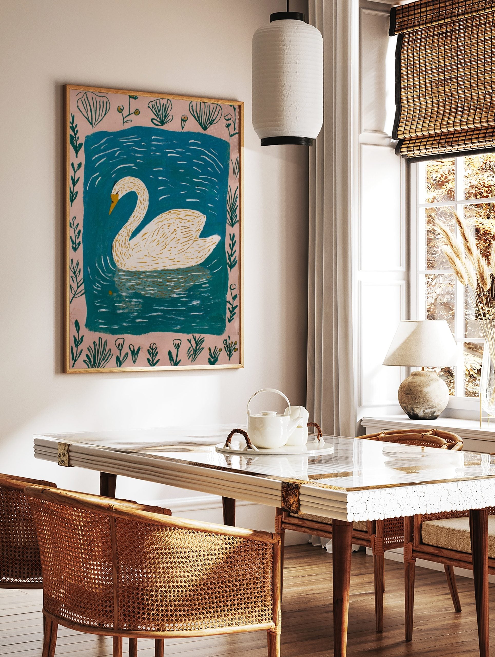Illustrative white swan with yellow beak swimming in blue water, framed by a pale pink botanical, in a styled room mockup
