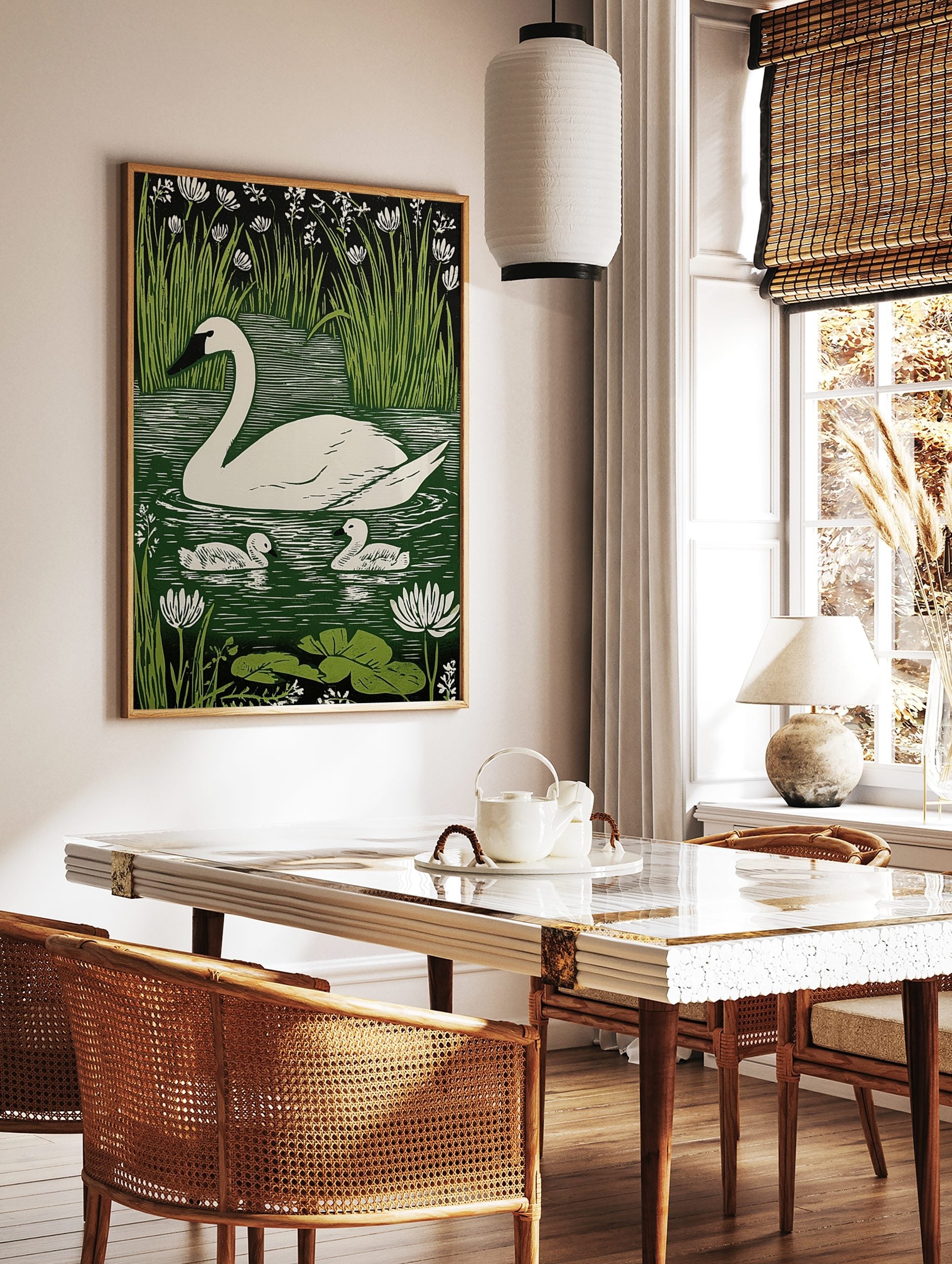 White swan and two cygnets on green water with reeds and white flowers in linocut print style, in a styled room mockup
