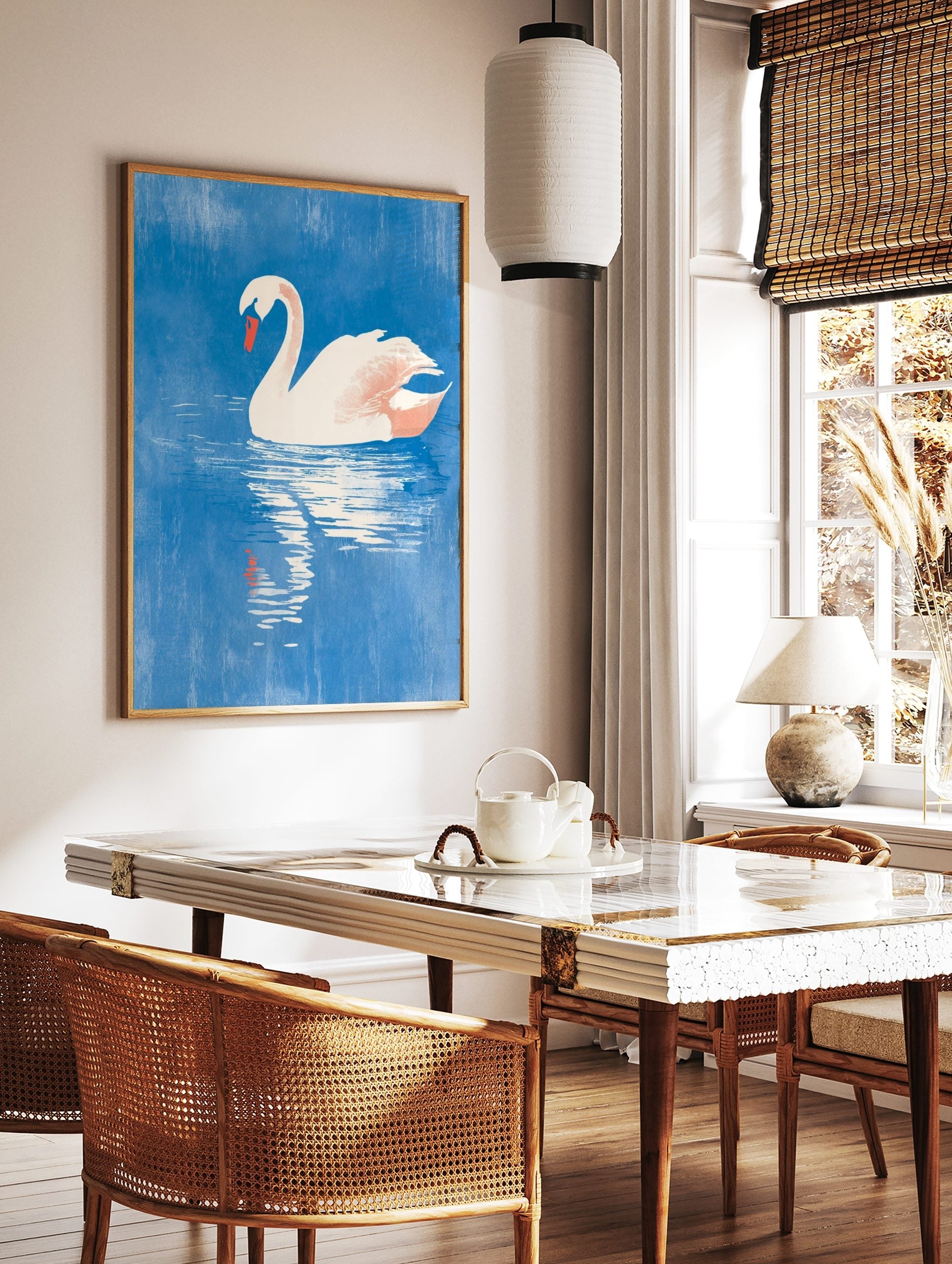 White swan with orange beak floating on textured blue water, with its reflection visible below, in a styled room mockup
