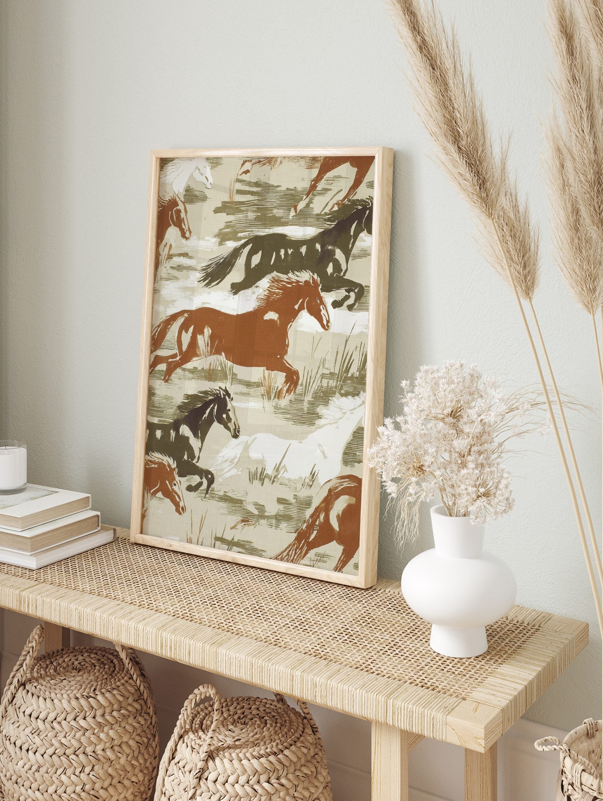 Illustrative print of wild horses galloping in brown, white, and dark green tones on a beige, in an alternate framed mockup