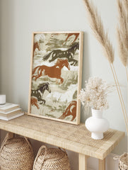 Illustrative print of wild horses galloping in brown, white, and dark green tones on a beige, in an alternate framed mockup