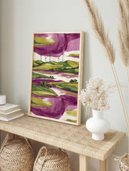 Modern landscape art print with green hills, wind turbines, purple water, and a purple and, in an alternate framed mockup