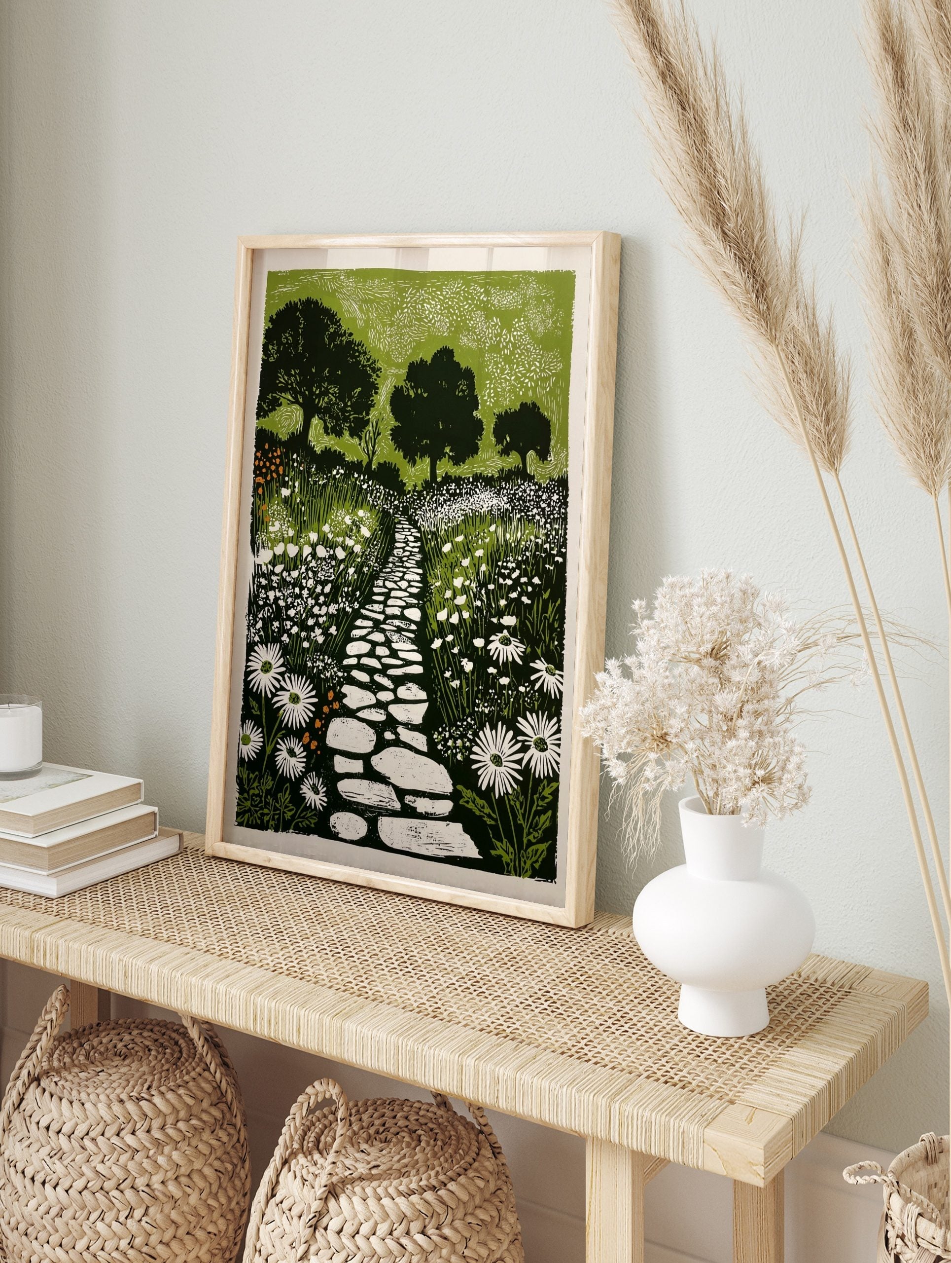 Linocut-style garden print with a winding stone path, white daisy flowers, and dark green, in an alternate framed mockup