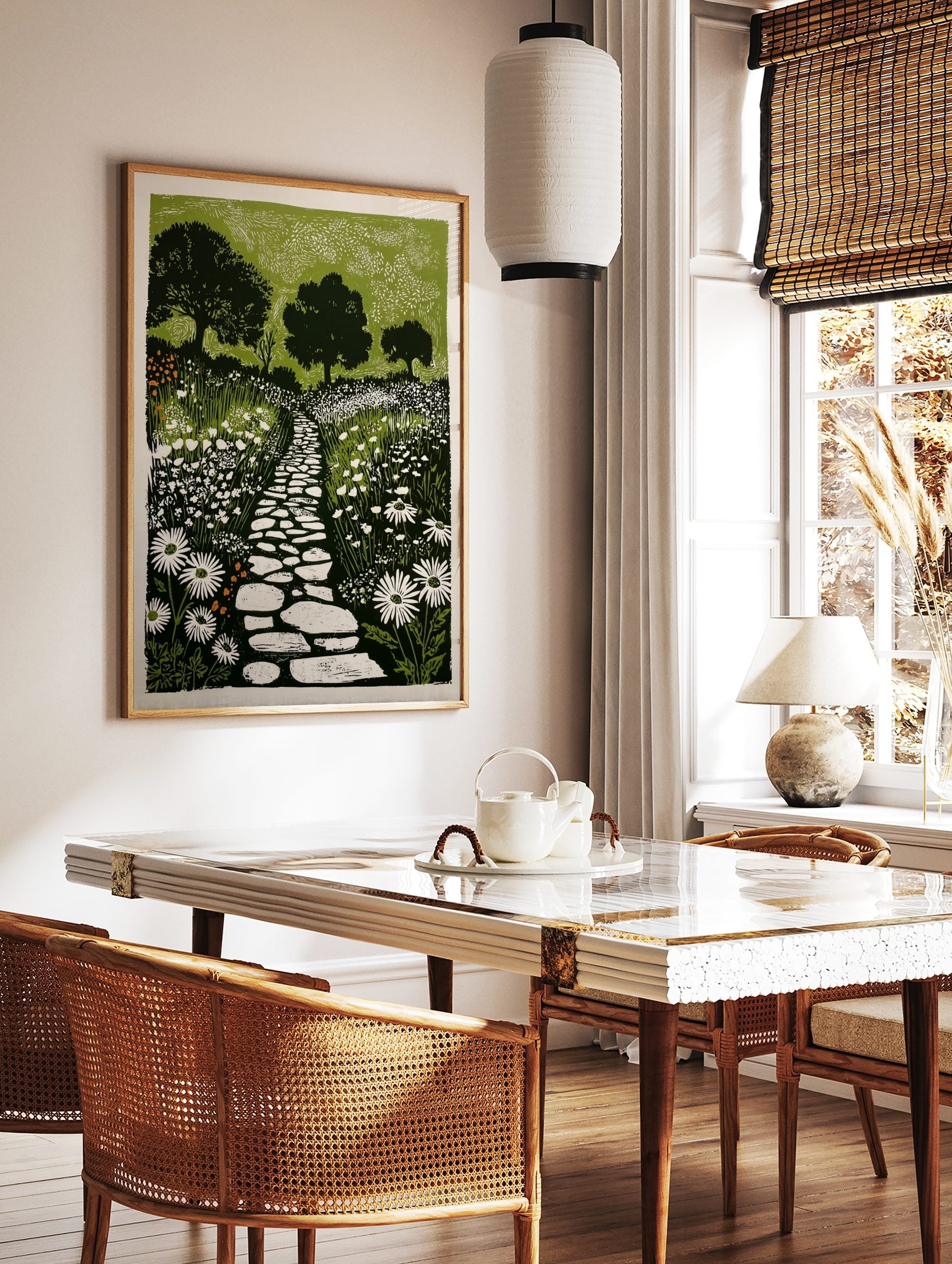 Linocut-style garden print with a winding stone path, white daisy flowers, and dark green trees, in a styled room mockup
