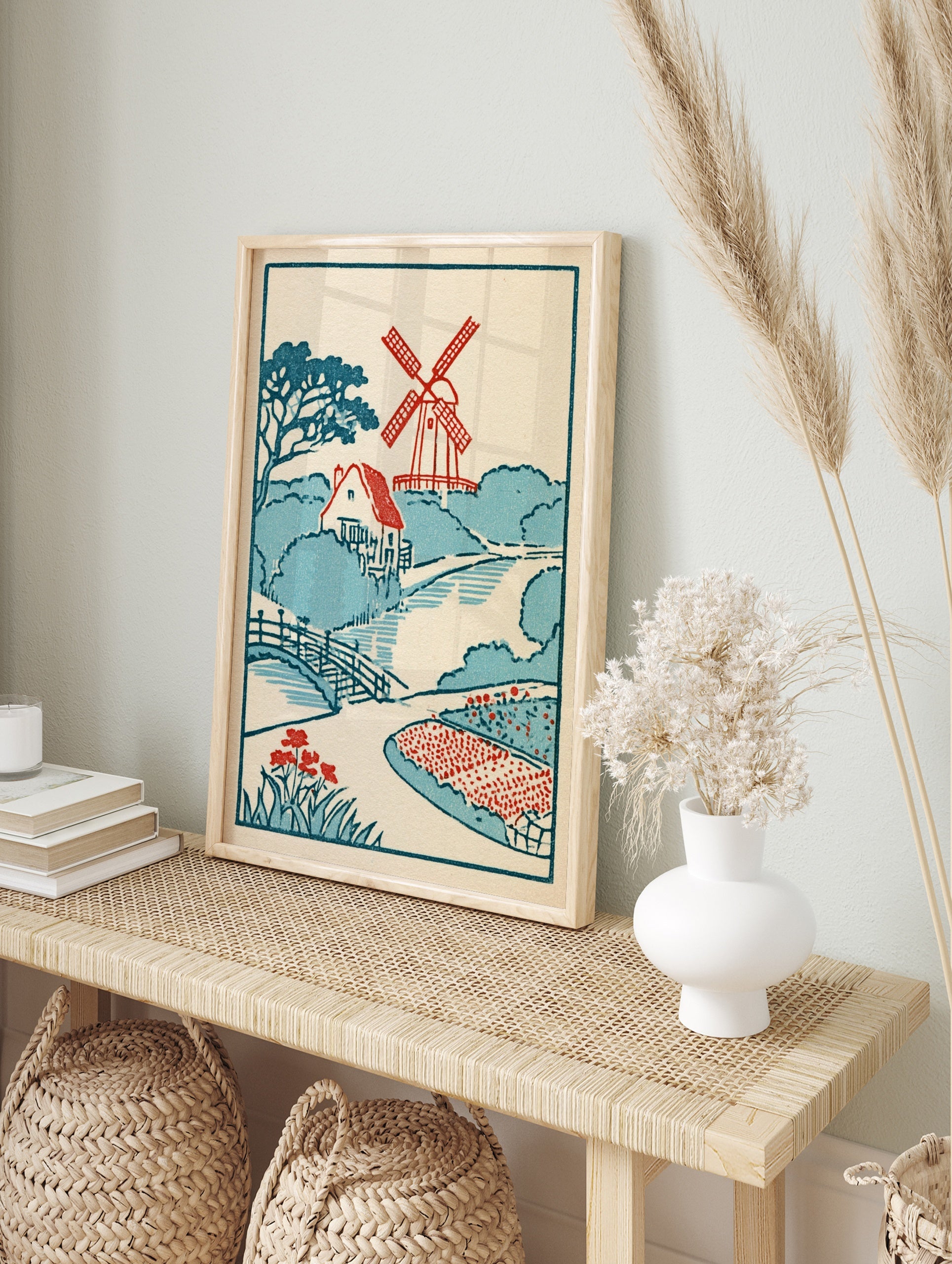 Vintage-style illustrative print featuring a red windmill, cottage, arched bridge, and red, in an alternate framed mockup