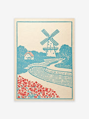 Illustrative windmill landscape art print with a bridge, cottage, and red flowers in a blue and white colour palette