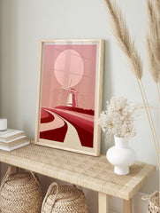 Minimalist windmill landscape wall art with a large pink sun and curved paths in shades of, in an alternate framed mockup
