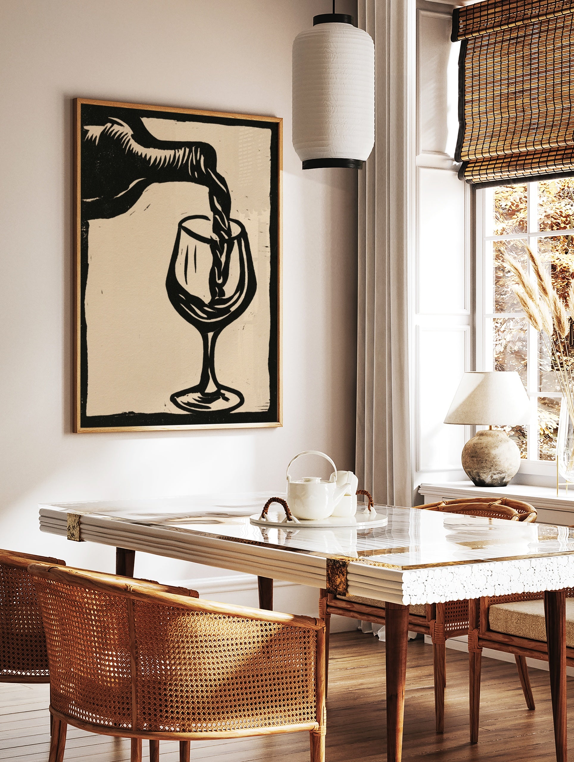 Linocut style black and white wall art of wine pouring into a glass on a neutral background, in a styled room mockup