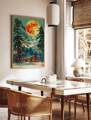 Illustrative print of a vibrant full moon over a snow-covered log cabin and tall pine trees at night, in a styled room mockup