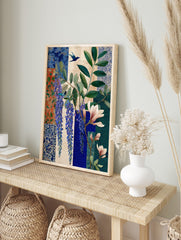 Botanical art print with purple wisteria, pink magnolia, green leaves, and two blue birds on, in an alternate framed mockup