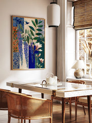 Botanical art print with purple wisteria, pink magnolia, green leaves, and two blue birds on a, in a styled room mockup